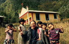 图3.省摄协刘明主席在雄当村与独龙族小朋友合影