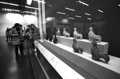 　观众在参观鸡年文物展览。