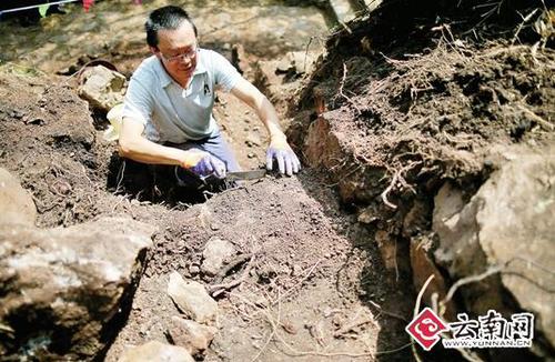 工作人员在清理石碑基座的泥土
