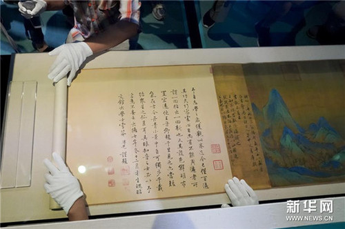 故宫博物院的工作人员将《千里江山图》布置到展柜中